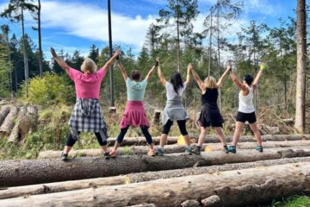 grupa stojąca na balach drewna